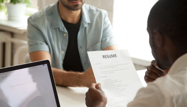African-american hr manager holding reading applicants resume at