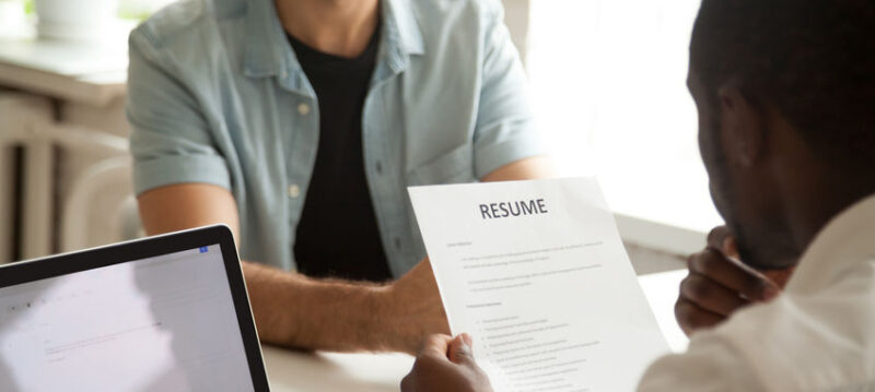 African-american hr manager holding reading applicants resume at