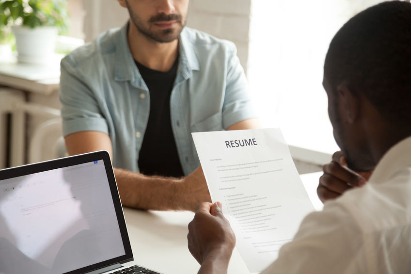 African-american hr manager holding reading applicants resume at